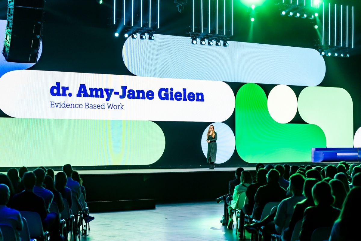 Spreker Amy-Jane Gielen op het podium over de kracht van kleine gewoontes op een bedrijfsevent